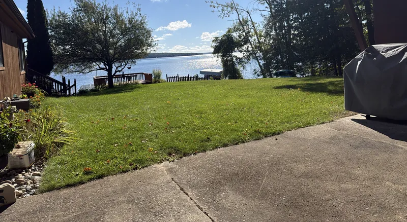 Mowed lakefront lawn with the lake behind it