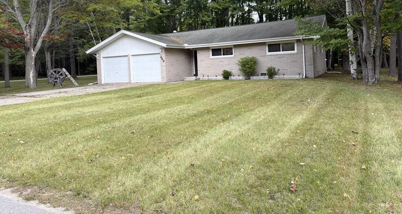 Straight mowing stripes across the front lawn of a ranch home