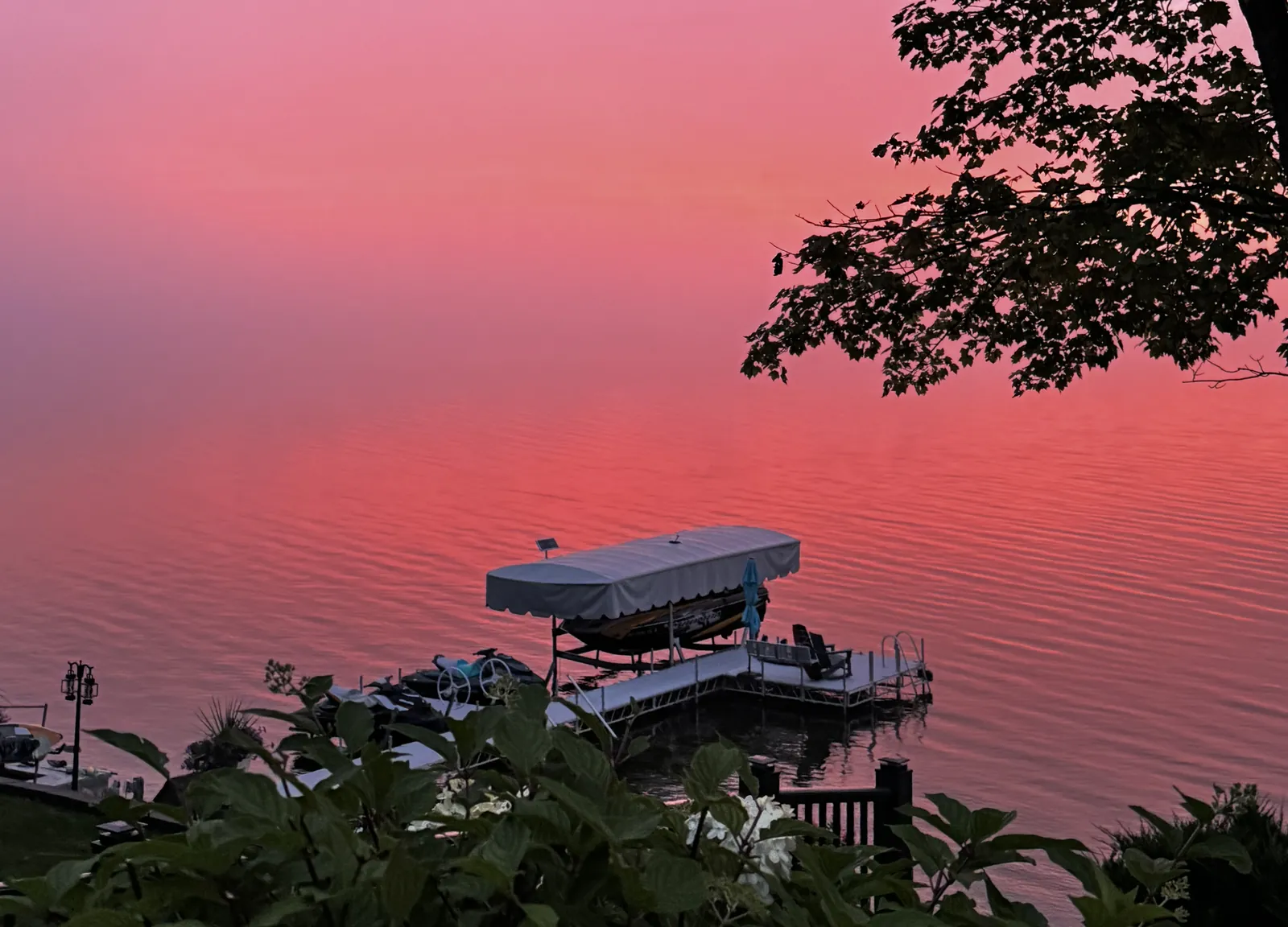 A boat lift and dock on a Northern Michigan lake at sunset