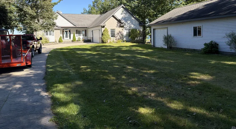Freshly mowed lawn beside a long driveway